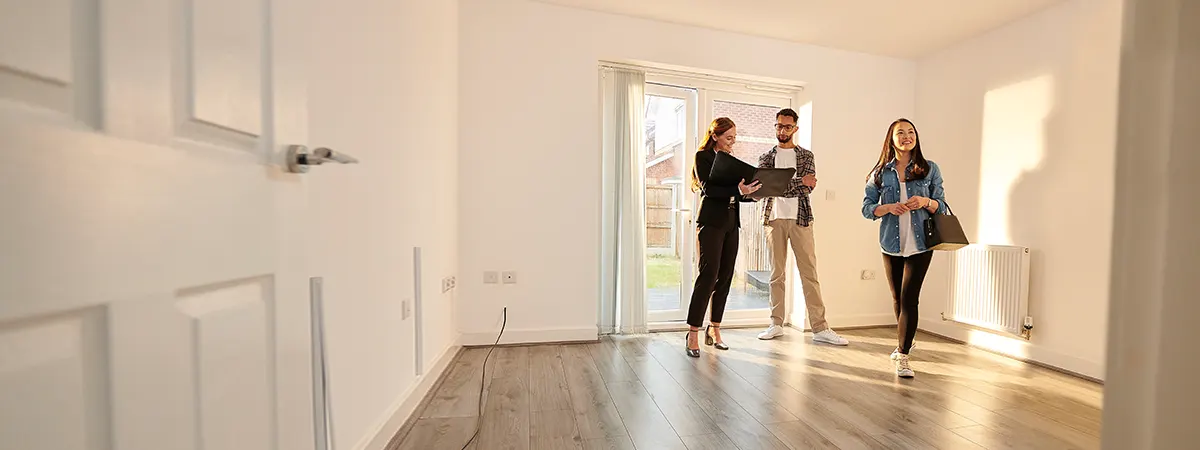 Couple with a representative looking at an empty house
